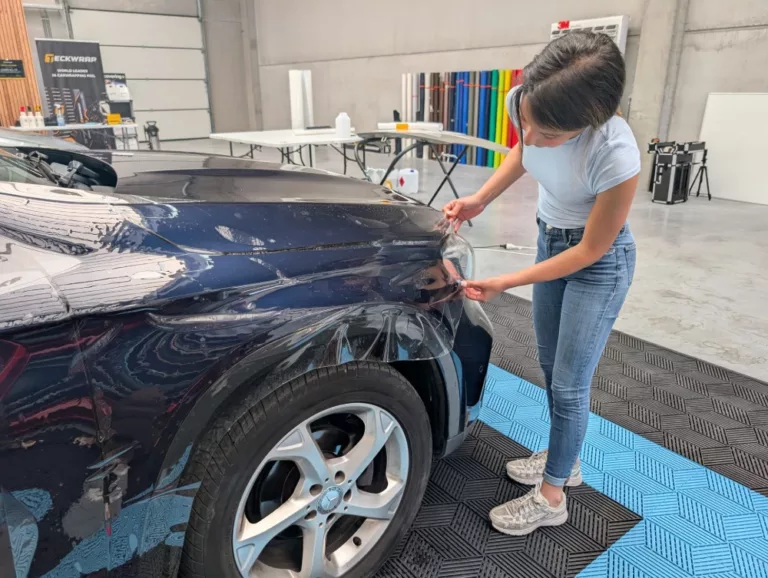 Stagiaire en formation PPF réalisant la pose d’un film de protection automobile