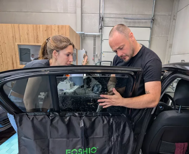Stagiaire en formation vitres teintées pendant un exercice pratique de pose